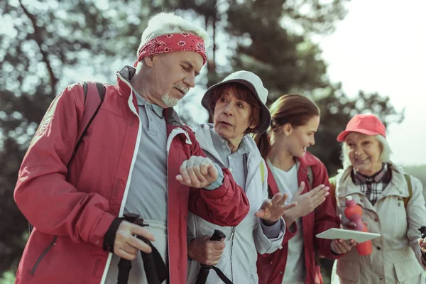 Group of elderly tourists checking time and direction — Stock Photo, Image