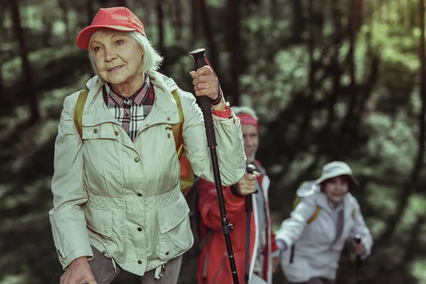 Elderly woman feeling tired of hiking in mountains