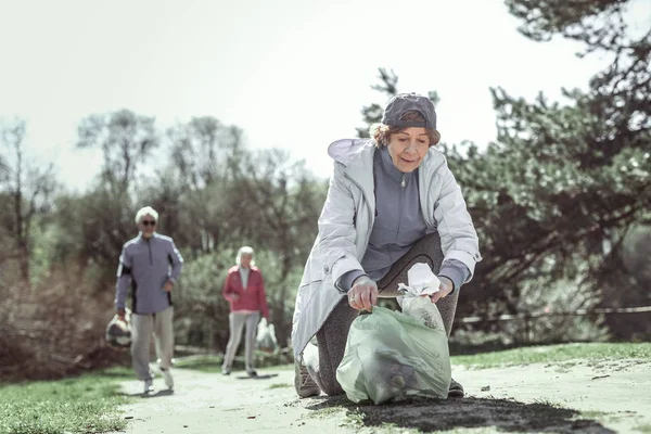 Модная старушка в серой шляпе помогает другим пожилым людям — стоковое фото