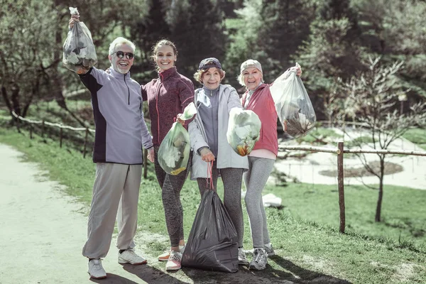 Счастливая команда добровольцев улыбается, потому что помогает окружающей среде — стоковое фото