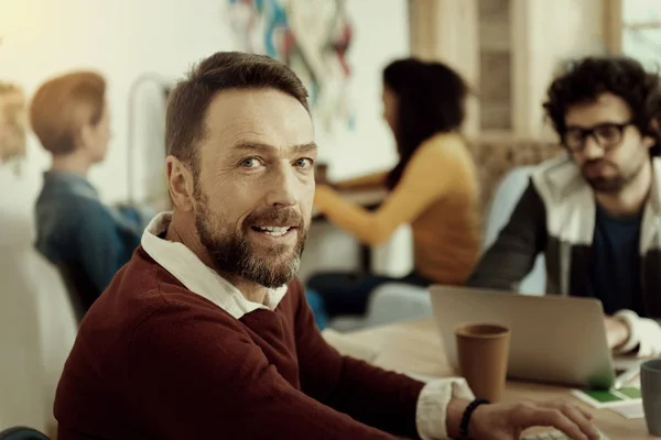 Hombre sonriente en un suéter marrón buscando satisfecho —  Fotos de Stock