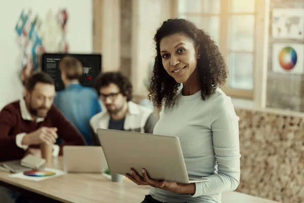 Sonriente mujer afroamericana con un ordenador portátil sentirse positivo — Foto de Stock