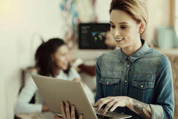 Amazing smiling woman with a tattoo working on her gadget — Stock Photo, Image