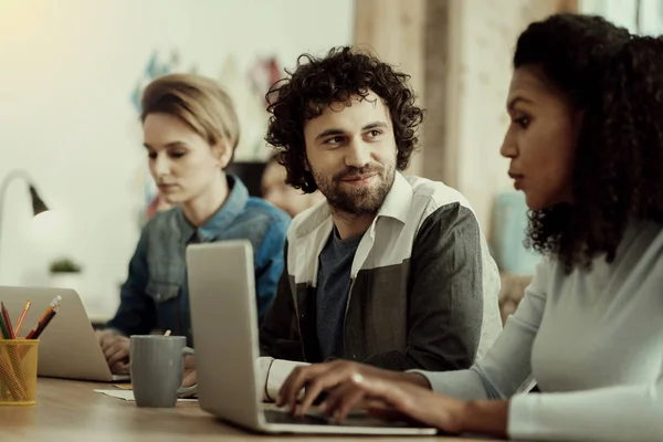 Dark-haired handsome office worker with a beard looking interested — Stock Photo, Image