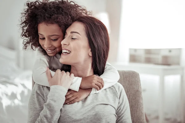 Klein schattig meisje haar mooie moeder knuffelen — Stockfoto