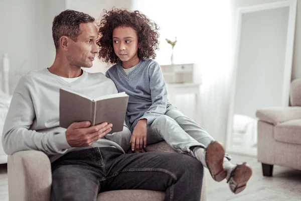 Ernstige vader en dochter die samen met het lezen van een boek — Stockfoto