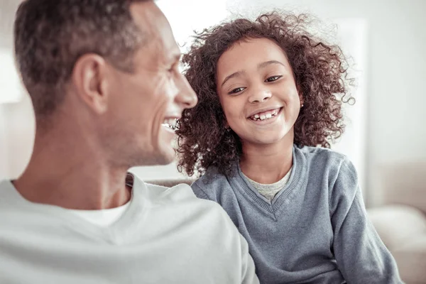 Joyful small girl spending good time with her father