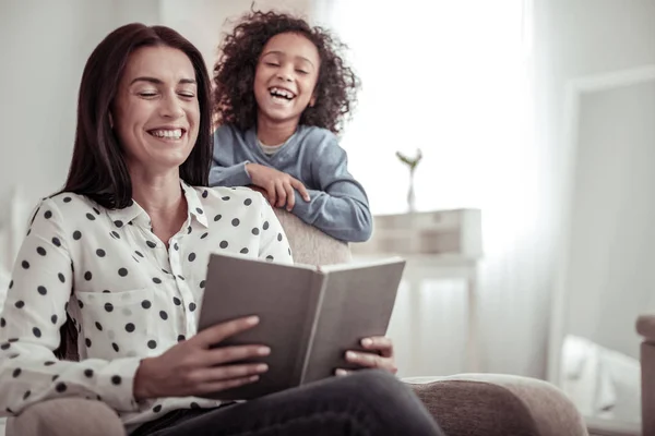 Vacker fin mor läser en bok tillsammans med en dotter — Stockfoto