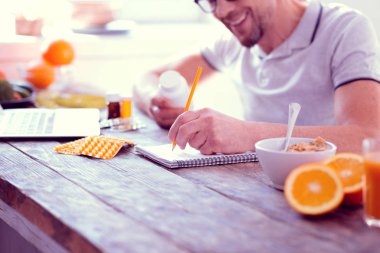 Sakallı adam önde gelen dengeli beslenme sırasında bazı notlar gülen