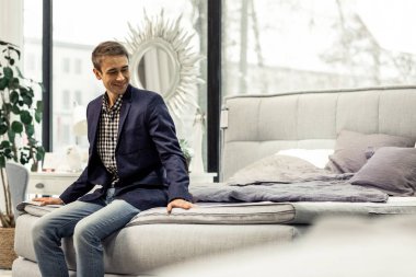 Yatakta koltuk mobilya showroom sahip yakışıklı neşeli beyler