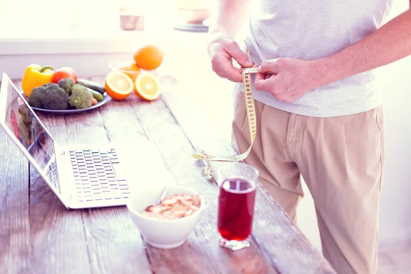 Hombre llevando un estilo de vida saludable teniendo sabroso desayuno saludable y la medición de la cintura — Foto de Stock