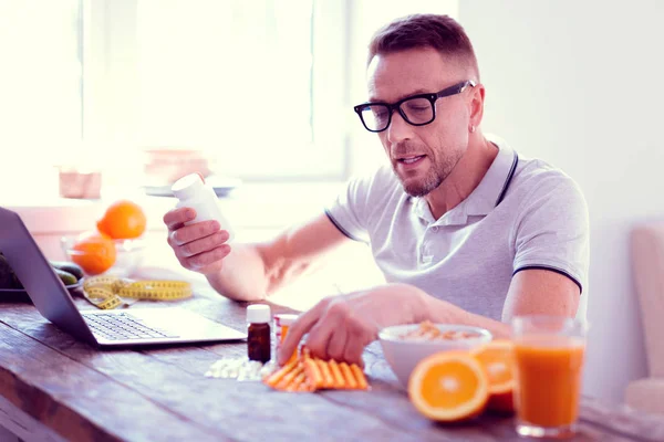 Adam onun diyet ve yaşam tarzı yeni vitaminler hakkında bilgi okuma geliştirme — Stok fotoğraf