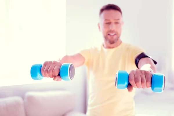 Beaming bearded man leading healthy lifestyle holding to blue hand weights — Stock Photo, Image