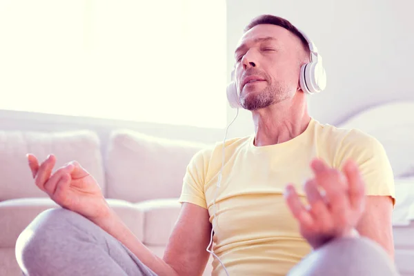 Человек чувствует спокойствие и облегчение во время медитации и концентрации на спокойной музыке — стоковое фото