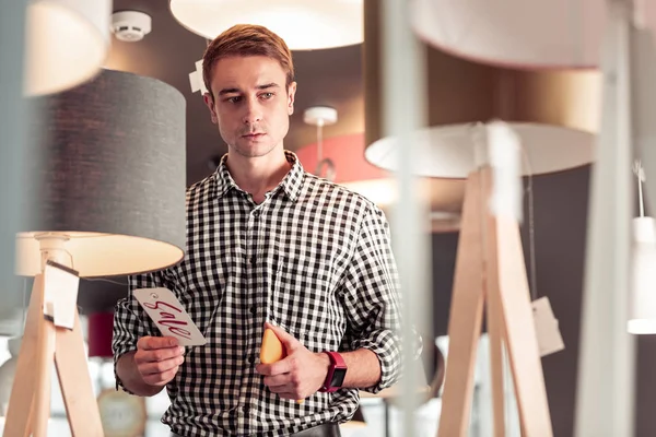 Porträt eines nachdenklichen, fokussierten erwachsenen Herrn mit Telefon im Showroom — Stockfoto