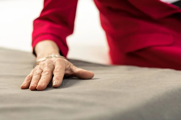 老化のベッドのシーツの上に横たわる女性の手のクローズ アップ画像 — ストック写真