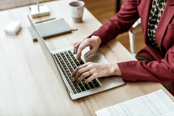 Concentrated adult woman in office outfit sitting in front of laptop — Stock Photo, Image