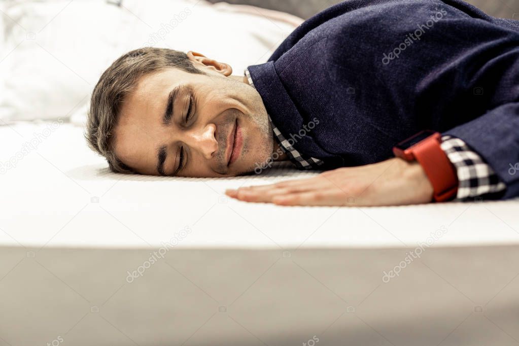 Portrait of serene man with eyes closed lying on bed