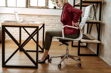 Pasif bir yaşam tarzı. Having problem ile kemikler ve kaslar sürekli ofiste oturan nedeniyle çekici kısa saçlı ofis çalışanı