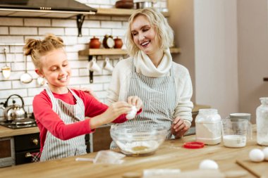 Gülen kısa saçlı kadın kızıyla memnun taşır