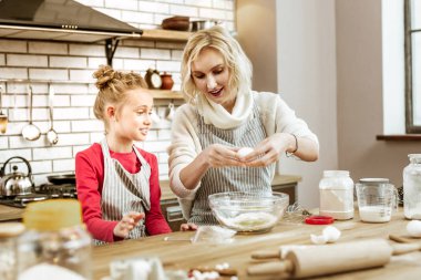 Sarışın güzel Bayan Beyaz kazaklı kasede yumurta atma
