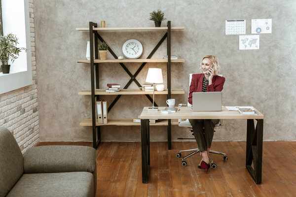 Beaming attractive short-haired woman in dark office costume