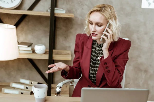 Actieve knappe vrouw oplossen van zakelijke momenten tijdens telefoon gesprek — Stockfoto