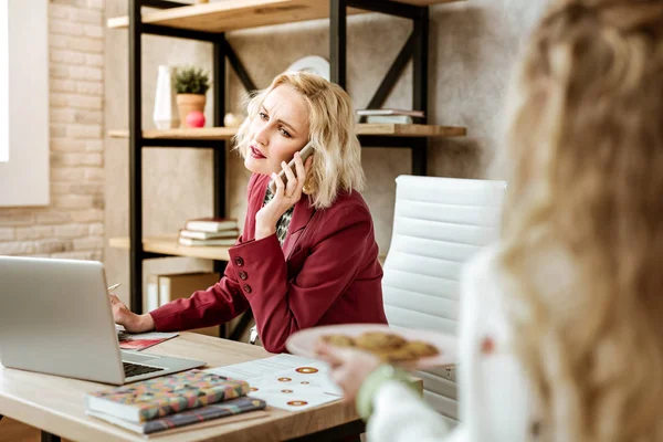 Mujer rubia cansada teniendo conversación de negocios en el gabinete — Foto de Stock