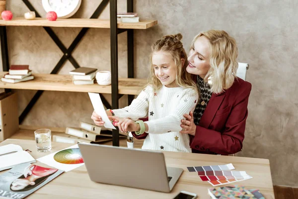 Leende nyfikna lilla barnet pekar på papper — Stockfoto