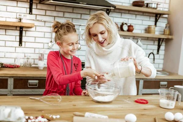 Nöjt leende kvinna hälla mjöl från klar flaska — Stockfoto