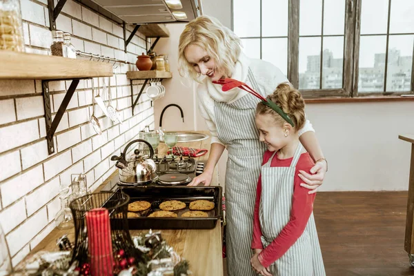 令人愉快的金发女士展示她的女儿完全准备好饼干 — 图库照片