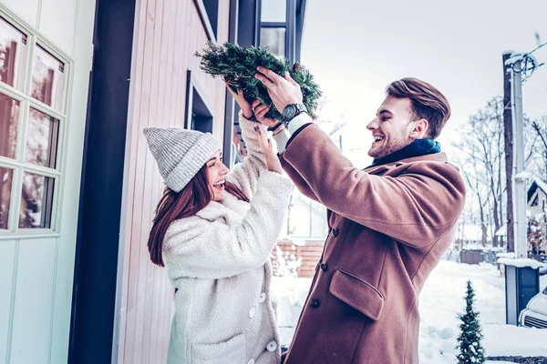 Coppia divertirsi fuori portando a casa decorazioni natalizie — Foto Stock