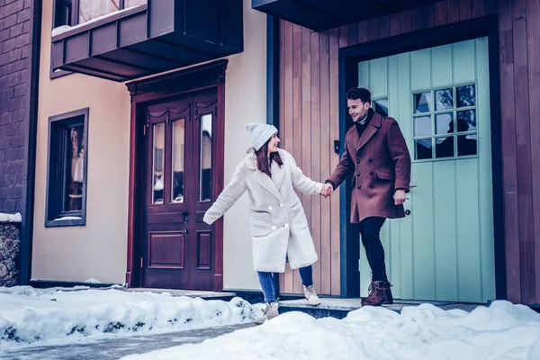 Felice coppia allegra in esecuzione fuori casa per camminare in inverno — Foto Stock