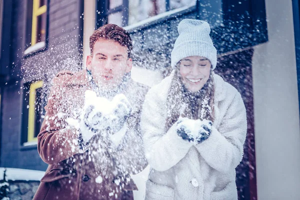 Coppia che indossa cappotti caldi e guanti che gioca con la neve — Foto Stock
