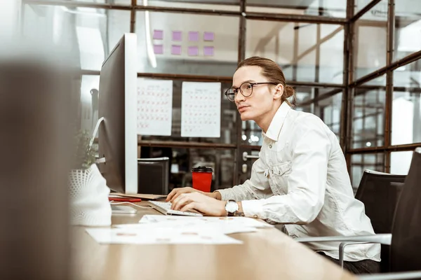 Un hombre serio e inteligente sentado en la computadora. —  Fotos de Stock