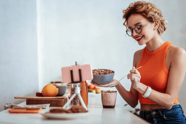 Mujer feliz positiva mostrando su desayuno saludable — Foto de Stock