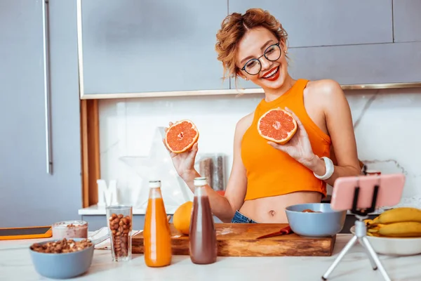 Encantada mujer feliz sosteniendo sabrosas naranjas frescas — Foto de Stock