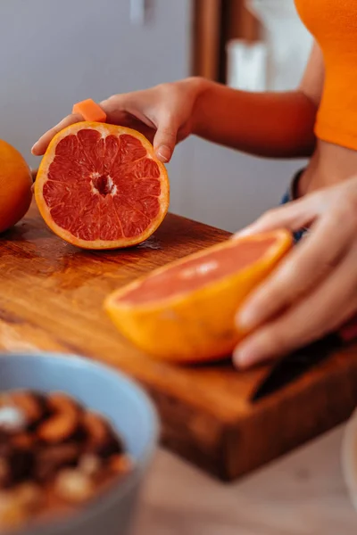 Selective focus of a grapefruit half on the cutting board — Stock Photo, Image
