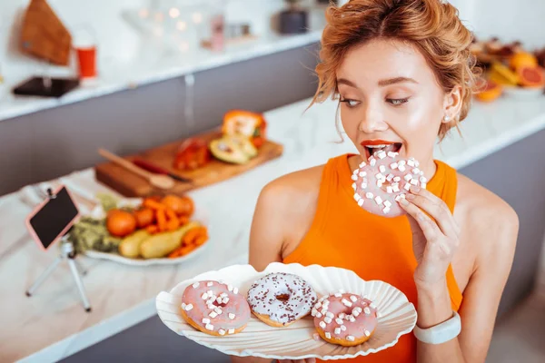 Bonita mujer atractiva comiendo rosquillas sabrosas dulces — Foto de Stock