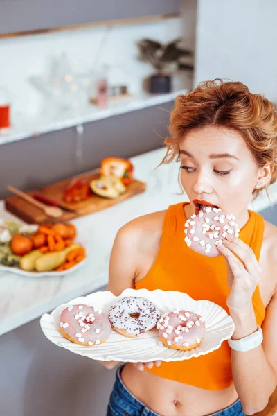 Hermosa joven sosteniendo un plato con rosquillas — Foto de Stock