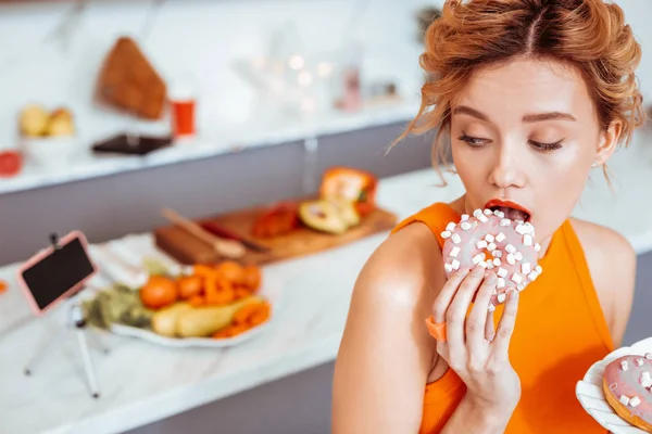 Schöne hübsche Frau isst einen leckeren Donut — Stockfoto