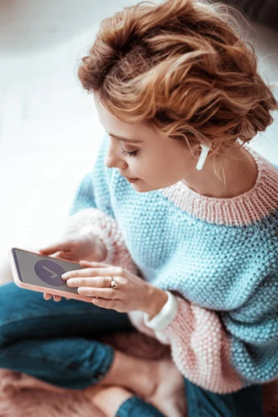 Mujer atractiva agradable mirando la pantalla del teléfono inteligente — Foto de Stock