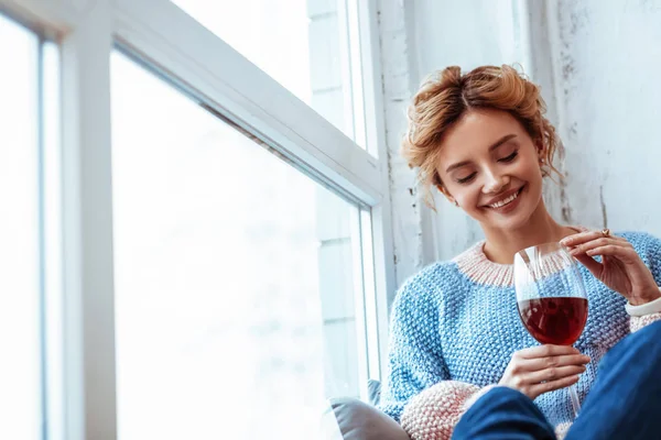 Веселая позитивная женщина смотрит на вино — стоковое фото