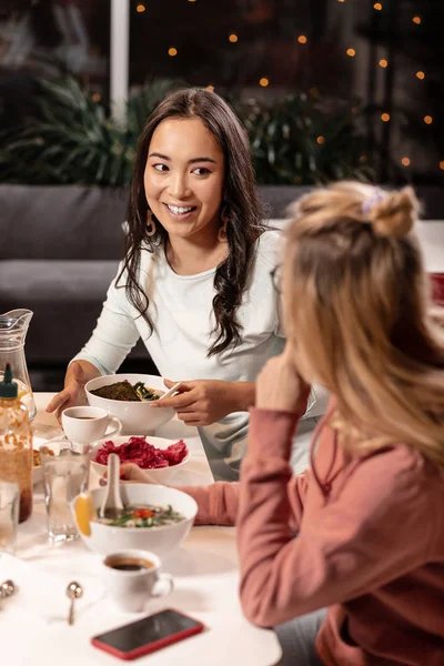 Tijdens een diner in restaurant twee meisjes die geheimen met elkaar delen. — Stockfoto