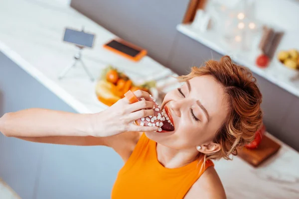 Позитивна весела жінка насолоджується смачним пончиком — стокове фото