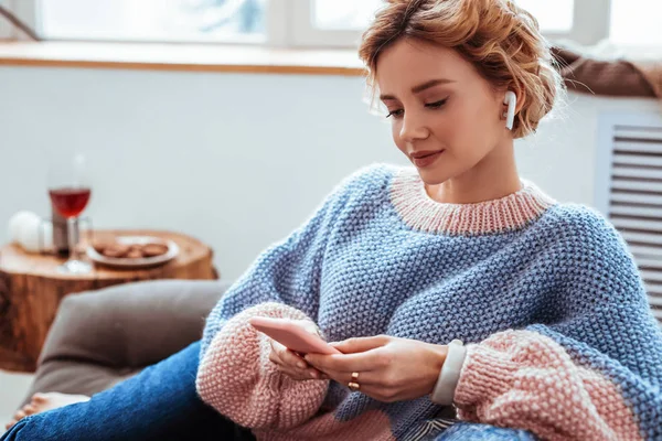 Mulher alegre e bonita usando fones de ouvido sem fio — Fotografia de Stock