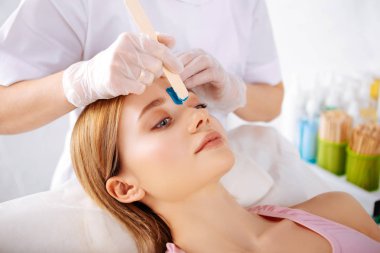 Kaşlar arasında çizgi depilatory krem koyarak uzmanı