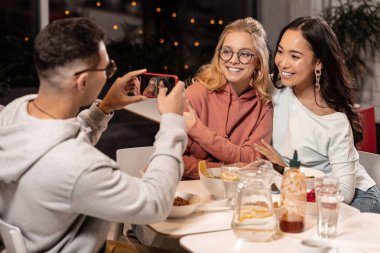 Onları ev yeme bir resim çekmek için adama iki bayan arkadaş.