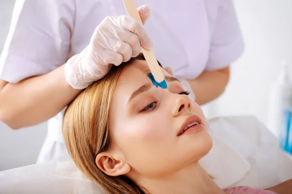 Close up of beauty specialist correcting form of eyebrows — Stock Photo, Image