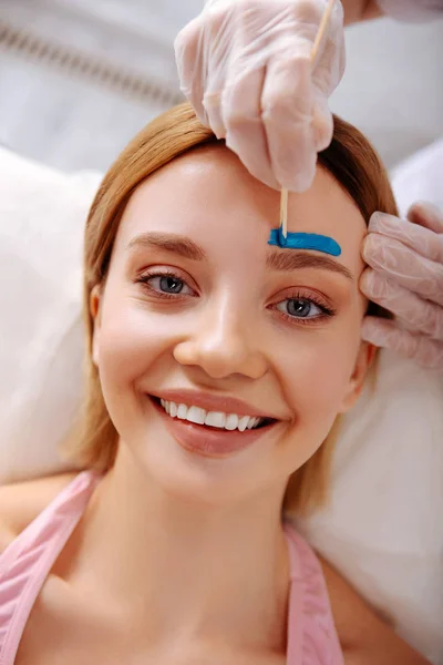 Stralend blauwogige cliënt van schoonheidssalon genieten van haar tijd — Stockfoto